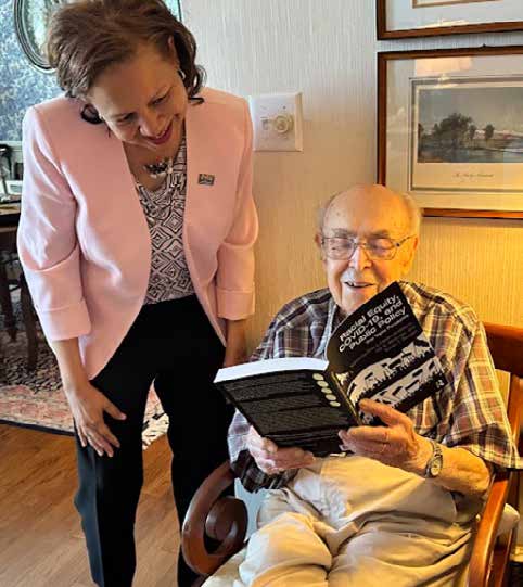 Laurin Henry with an old man reading a book