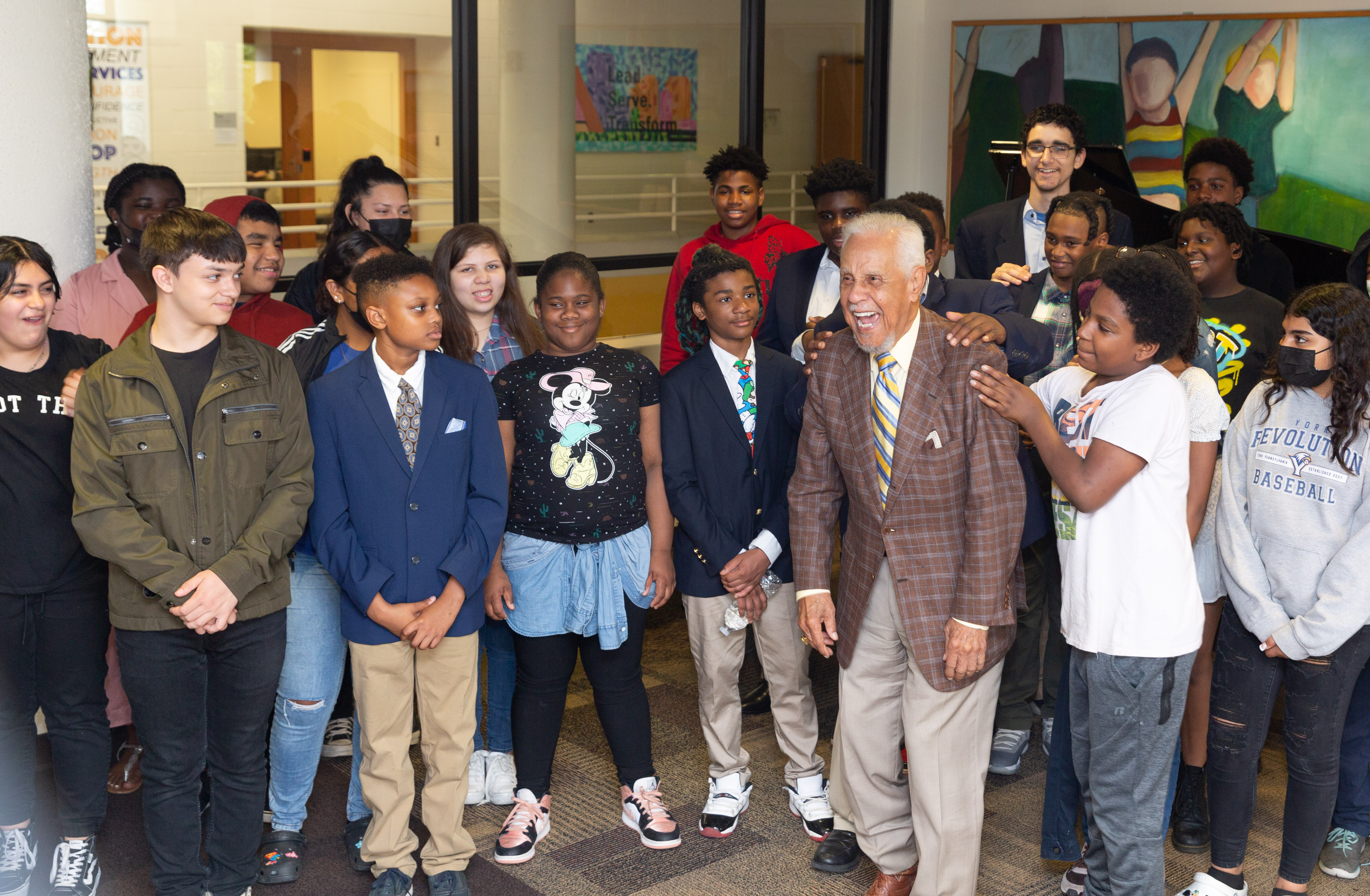 Governor Wilder standing with a group of school-aged children, laughing.