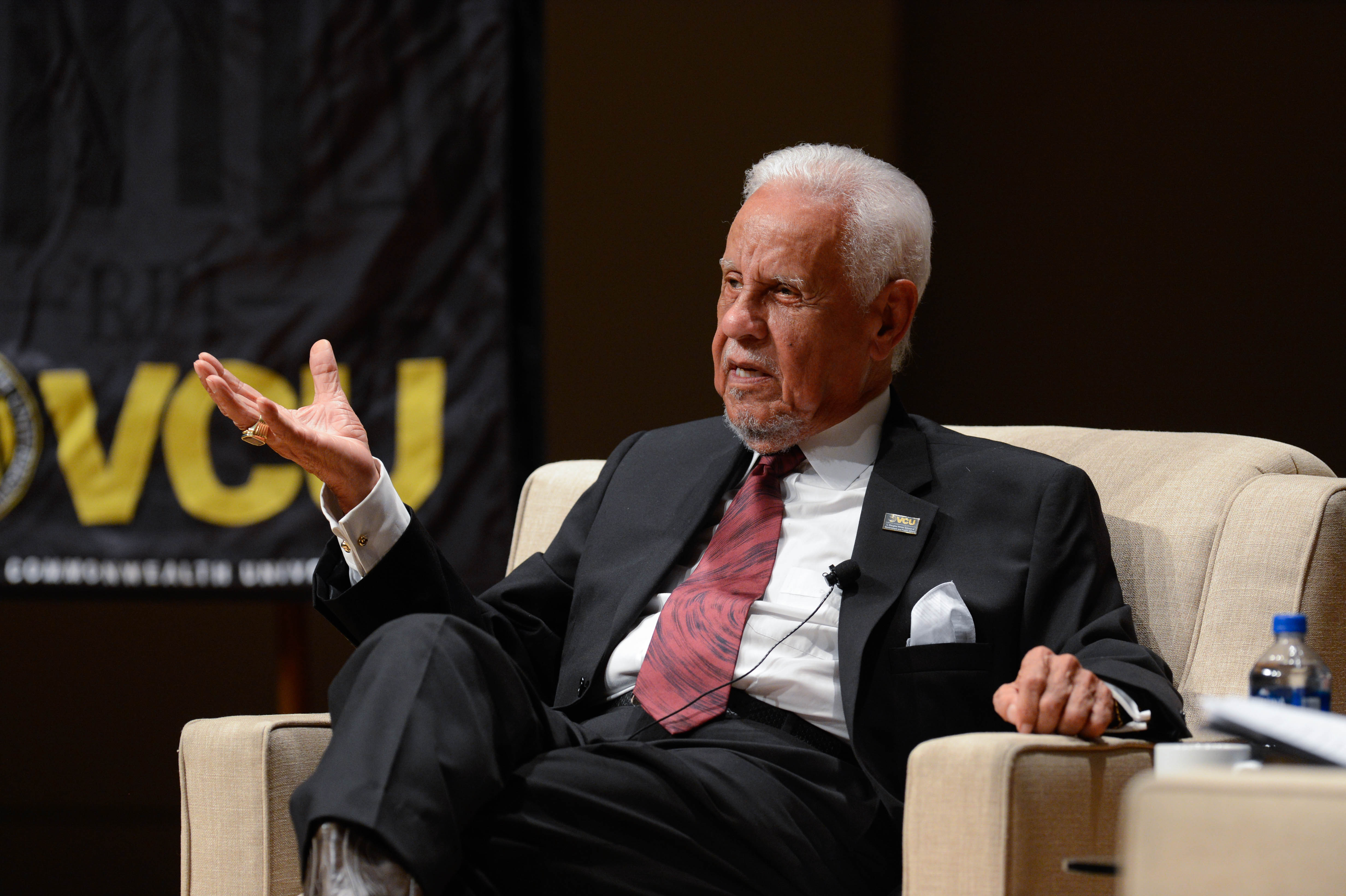 Wilder sitting and gesturing with one hand