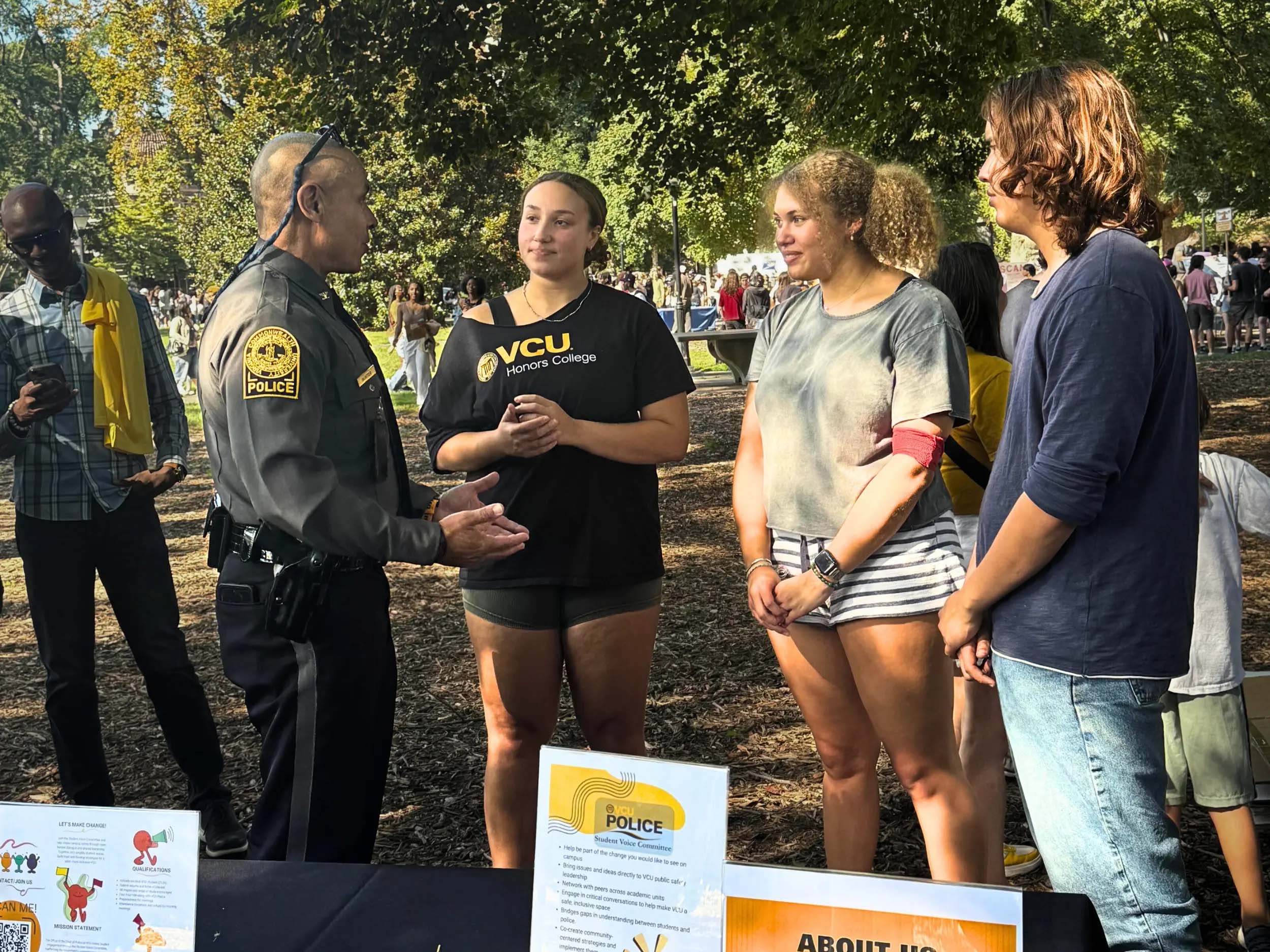 Members of the Student Voice Committee to the Office of the Chief of Police speak with VCU Police Chief Clarence T. Hunter Jr. at the 2025 SOVO Fair at Monroe Park.