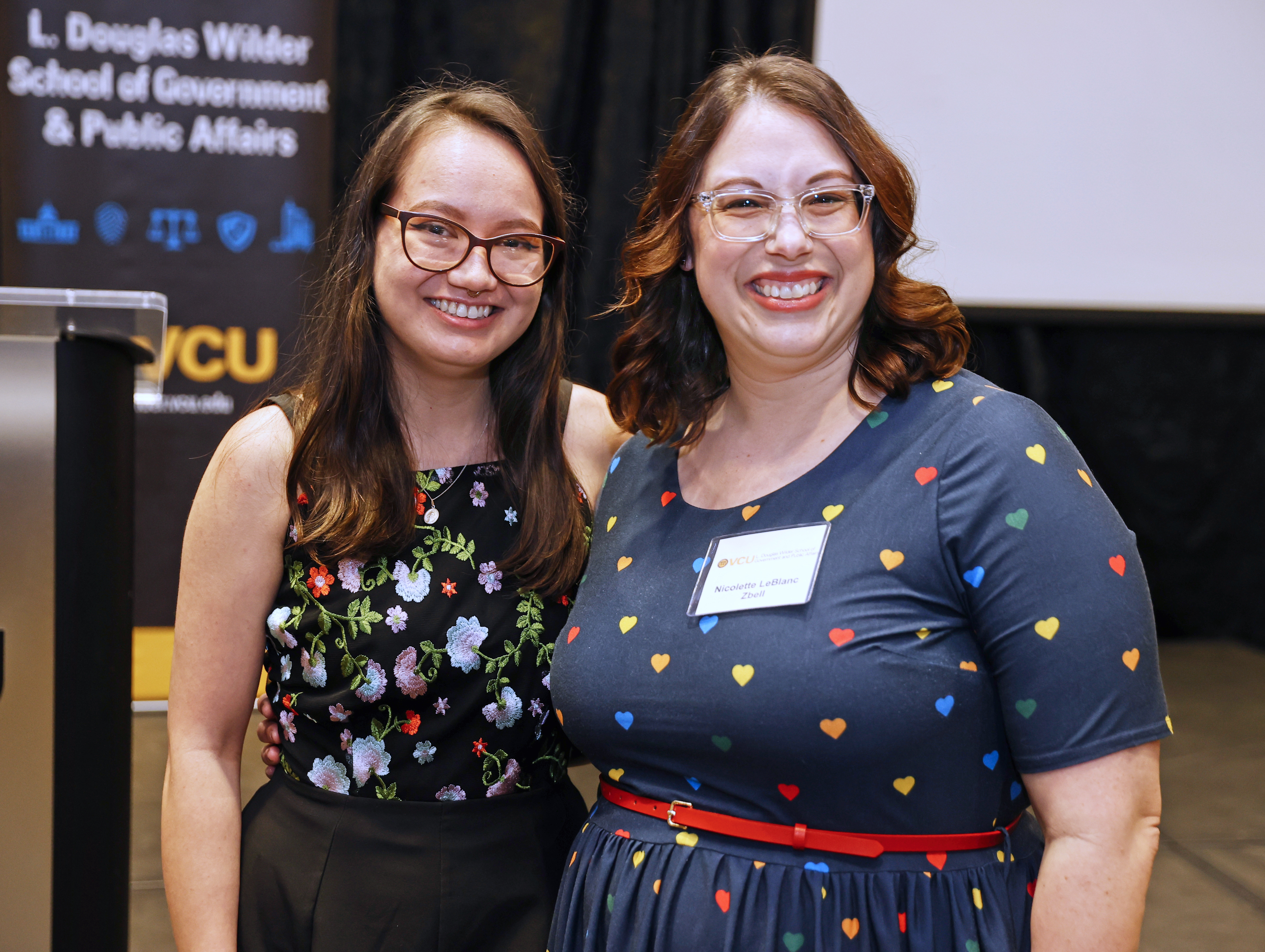 Nicolette Zbell (at right) enjoys working with students to help them “overcome, work around or bypass,” any barriers along their paths to earning their degree. Here she poses with Diana Hall (Urban & Regional Studies) at the Wilder School May 2023 Commencement.